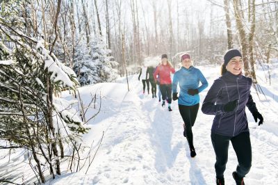 People run through the forest in winter